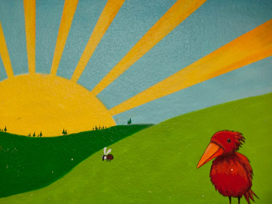 Kunstwerk mit einem roten Vogel und einem Kaninchen auf einem grünen Hügel.