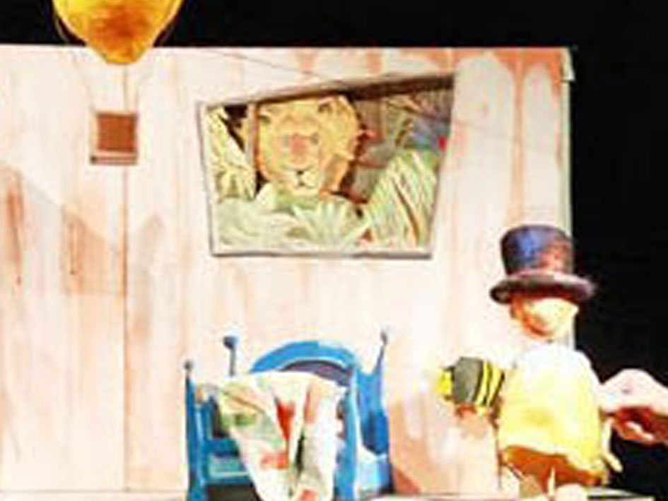 Eine Bühne mit einem Mann und einer Frau, die auf einem Stuhl sitzen und miteinander sprechen.