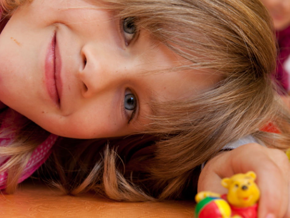 Ein Mädchen liegt entspannt auf dem Boden.