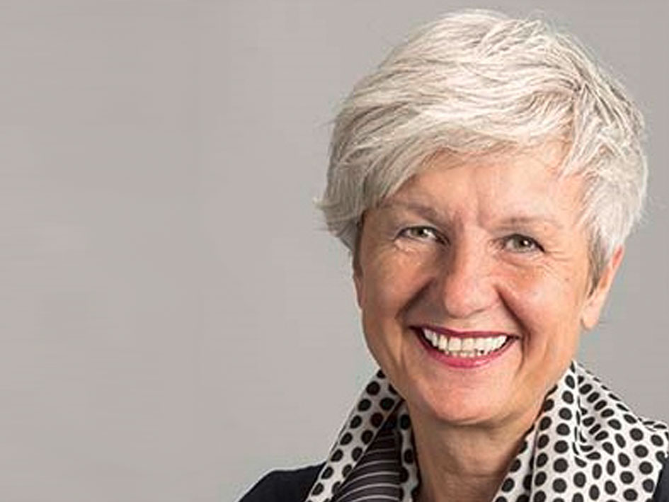 Eine Frau mit weißen Haaren, die einen stilvollen schwarz-weißen Schal trägt.