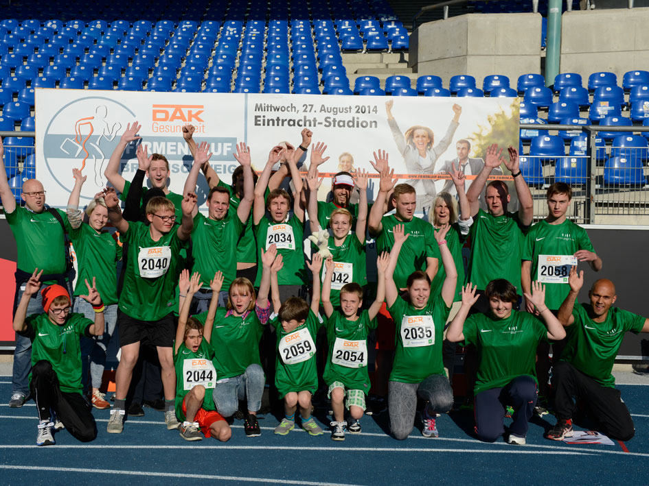 Menschen stehen zusammen und lächeln in die Kamera für ein Gruppenfoto.