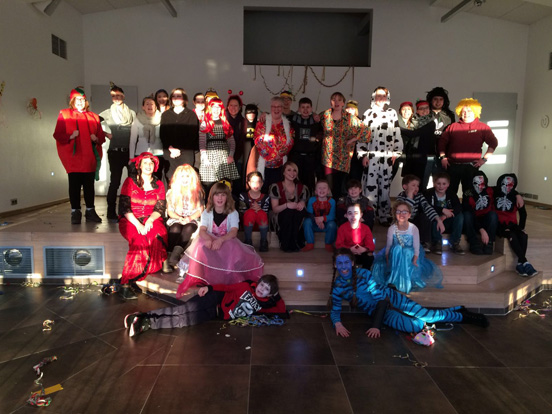 Eine Gruppe von Kindern, die in kreativen Kostümen für eine Feier posieren.