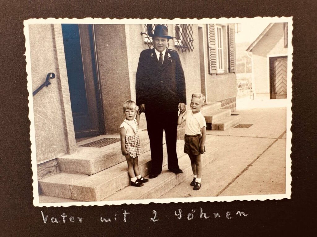 Historisches Foto: Vater mit zwei Söhnen, ca. 1950er Jahre, Schwarzweißaufnahme, Familienalbum, Kindheit, Generationen, Retro, Vintage.