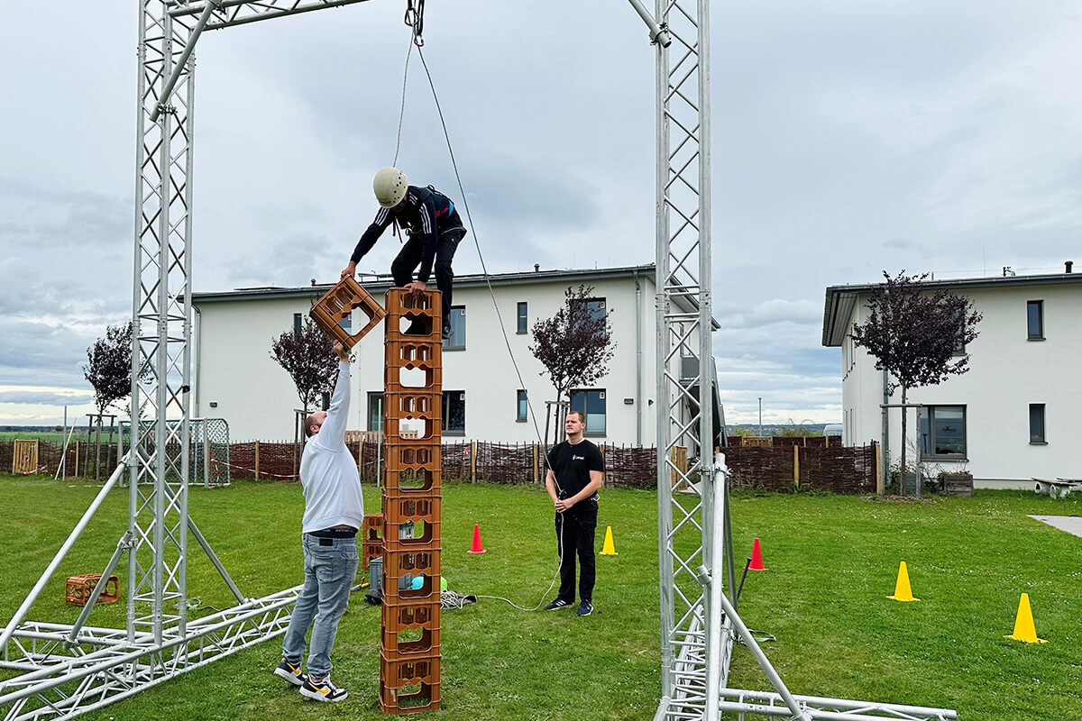 Zwei Personen klettern auf einer Holzstruktur.