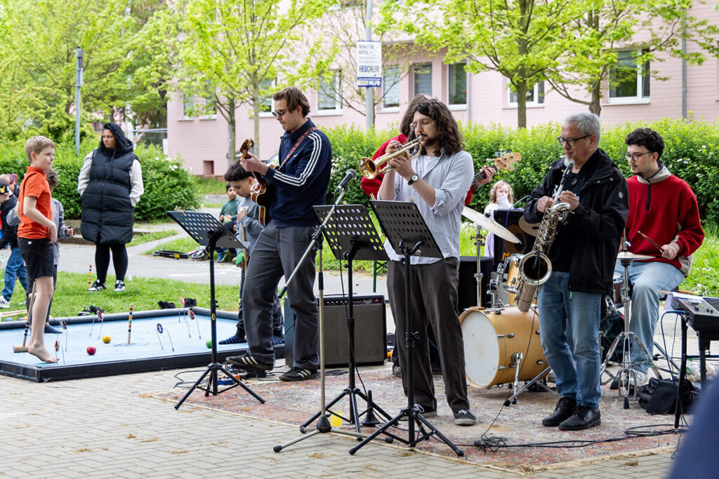 Eine Gruppe von Menschen spielt Musik auf einer Bühne.