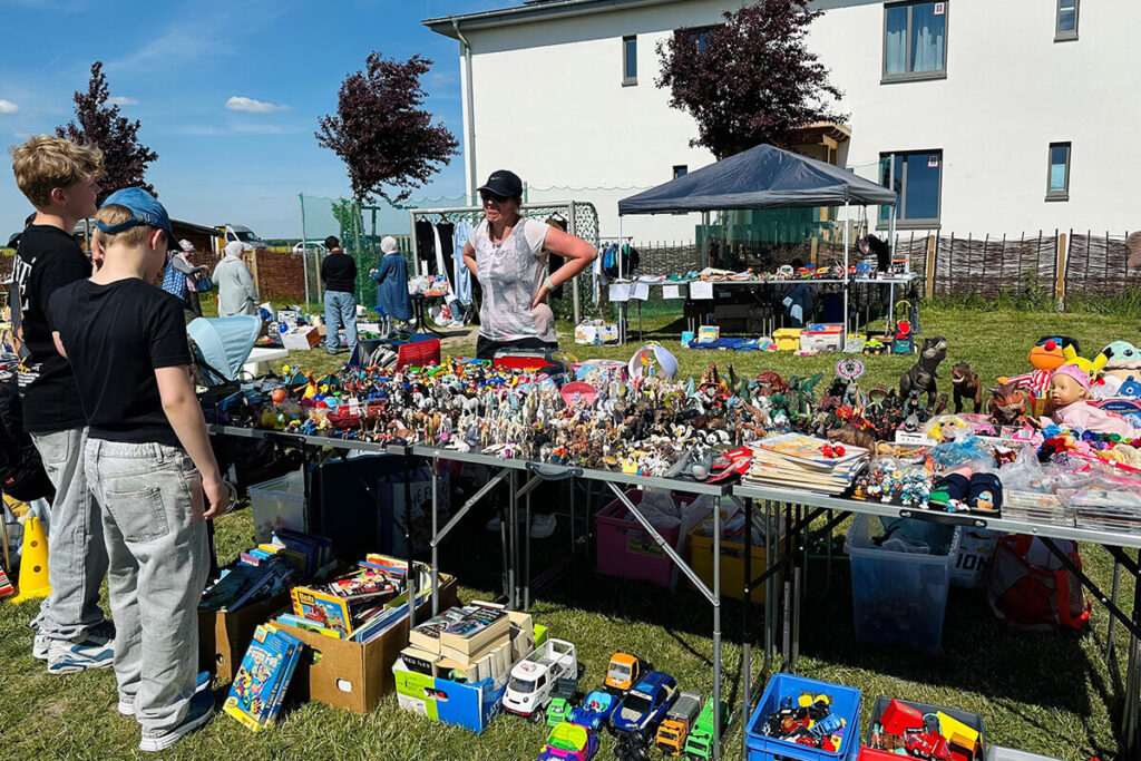 Eine Gruppe von Menschen steht um einen Tisch mit verschiedenen Spielzeugen.