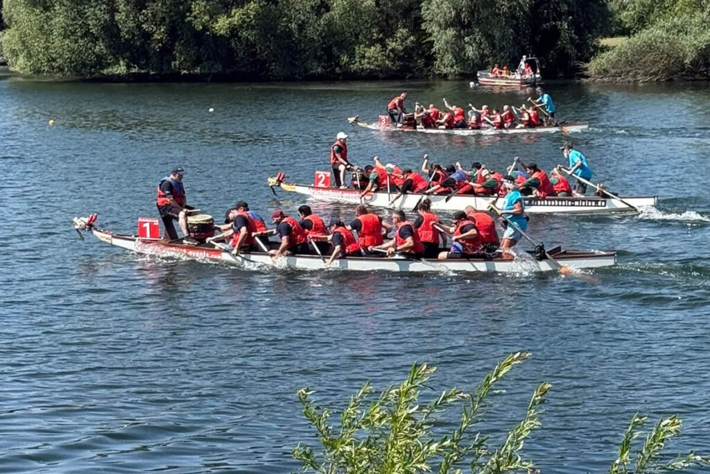 Eine Gruppe von Menschen in roten Schwimmwesten auf einem Boot.