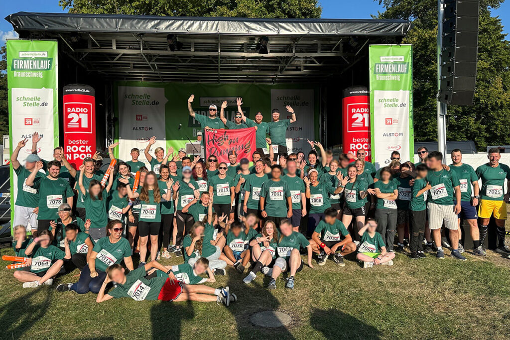 Eine Gruppe von Menschen in grünen Shirts steht auf einer Bühne.