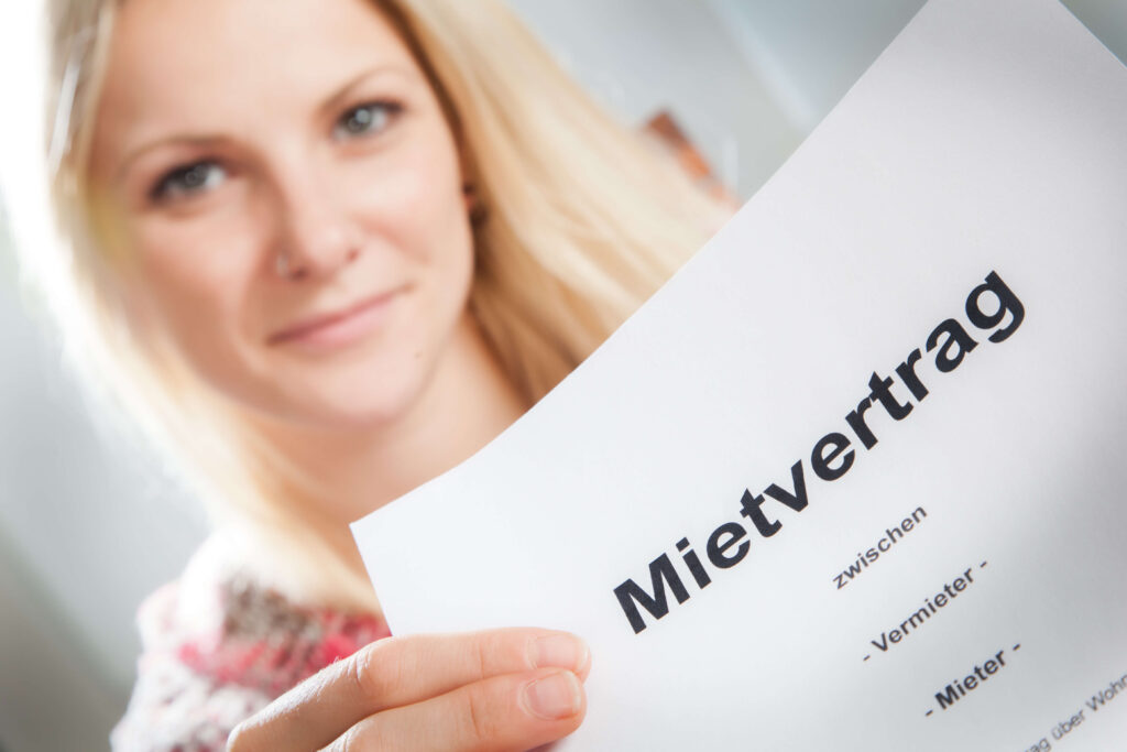 Eine Frau präsentiert ein Dokument mit der Aufschrift "Mietvertrag".