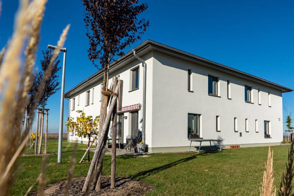 Ein Haus mit Garten und Rasen inmitten eines Feldes.