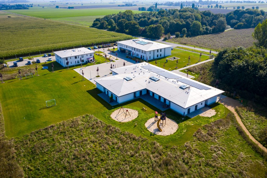 Aerialansicht eines großen Gebäudes, das einen Spielplatz in der Nähe zeigt.