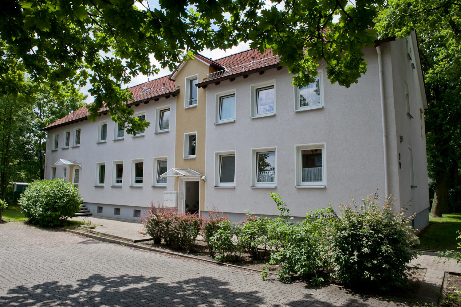 Ein Gebäude mit weißer Fassade und gelben Akzenten.