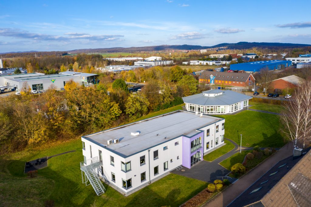 Aerial view eines Gebäudes mit lila Dach, das in einer städtischen Umgebung steht.